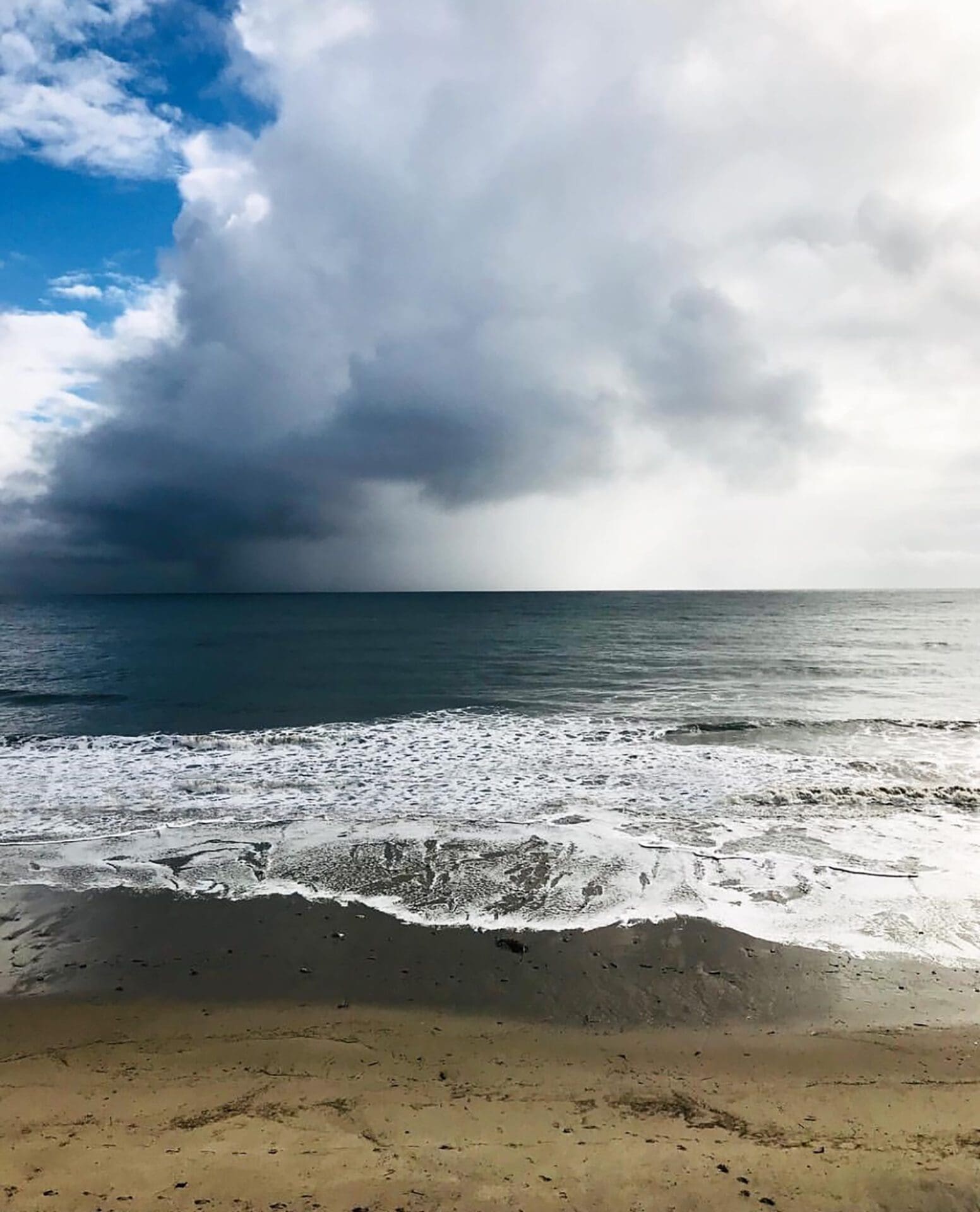 a stormy sky over the ocean and beach